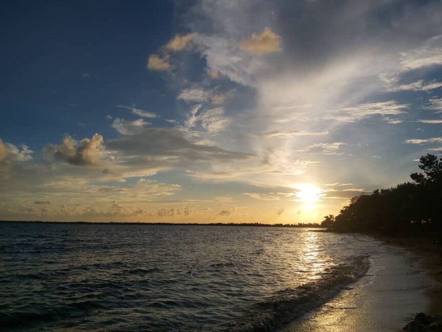 Sunset over a serene beach near Havana, Cuba, with gentle waves and a clear sky, offering a peaceful place to swim and sunbathe.